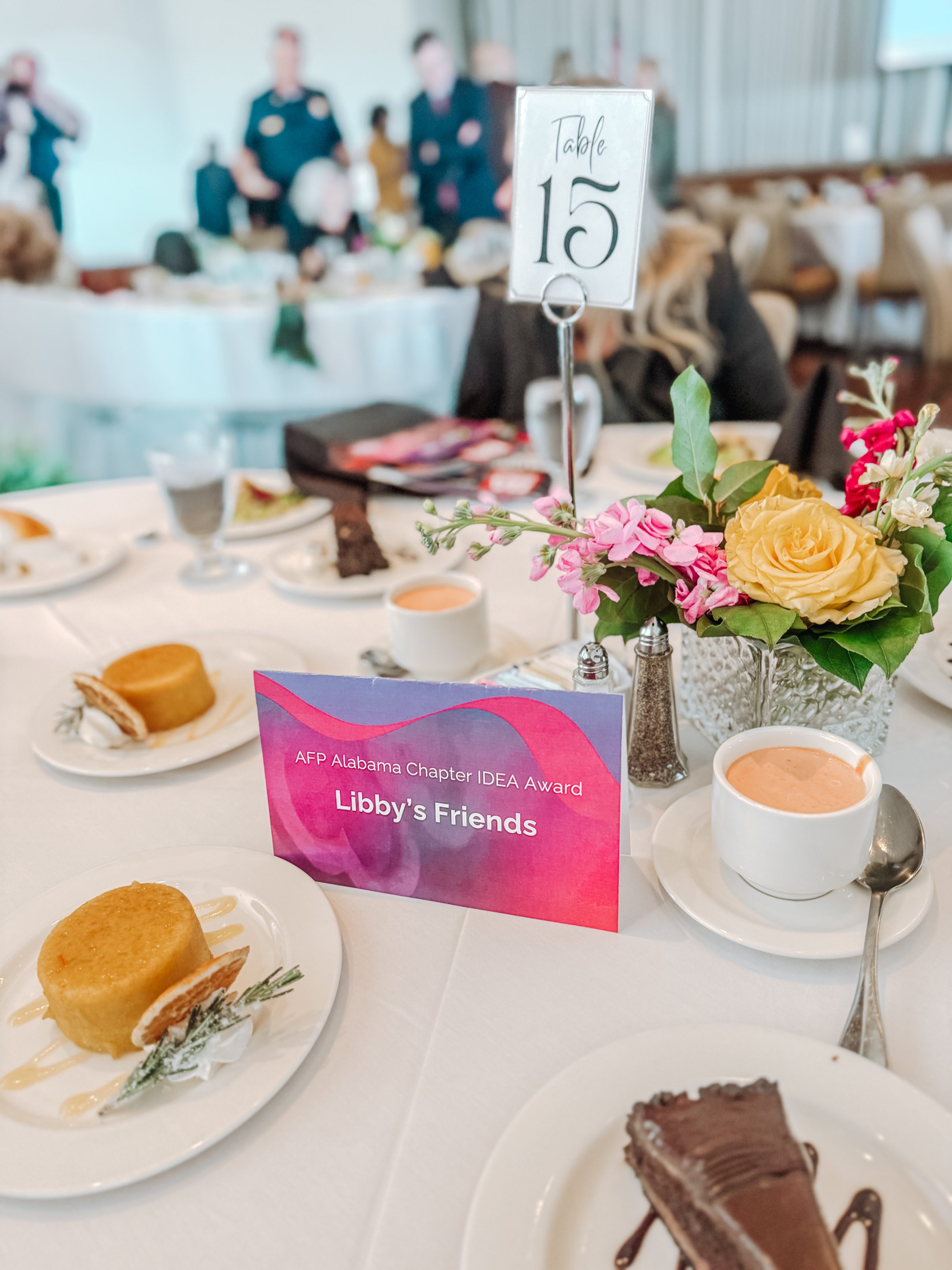 Award banquet table with desserts and flowers, Table 15 sign and “Libby’s Friends” AFP Alabama Chapter IDEA Award card.