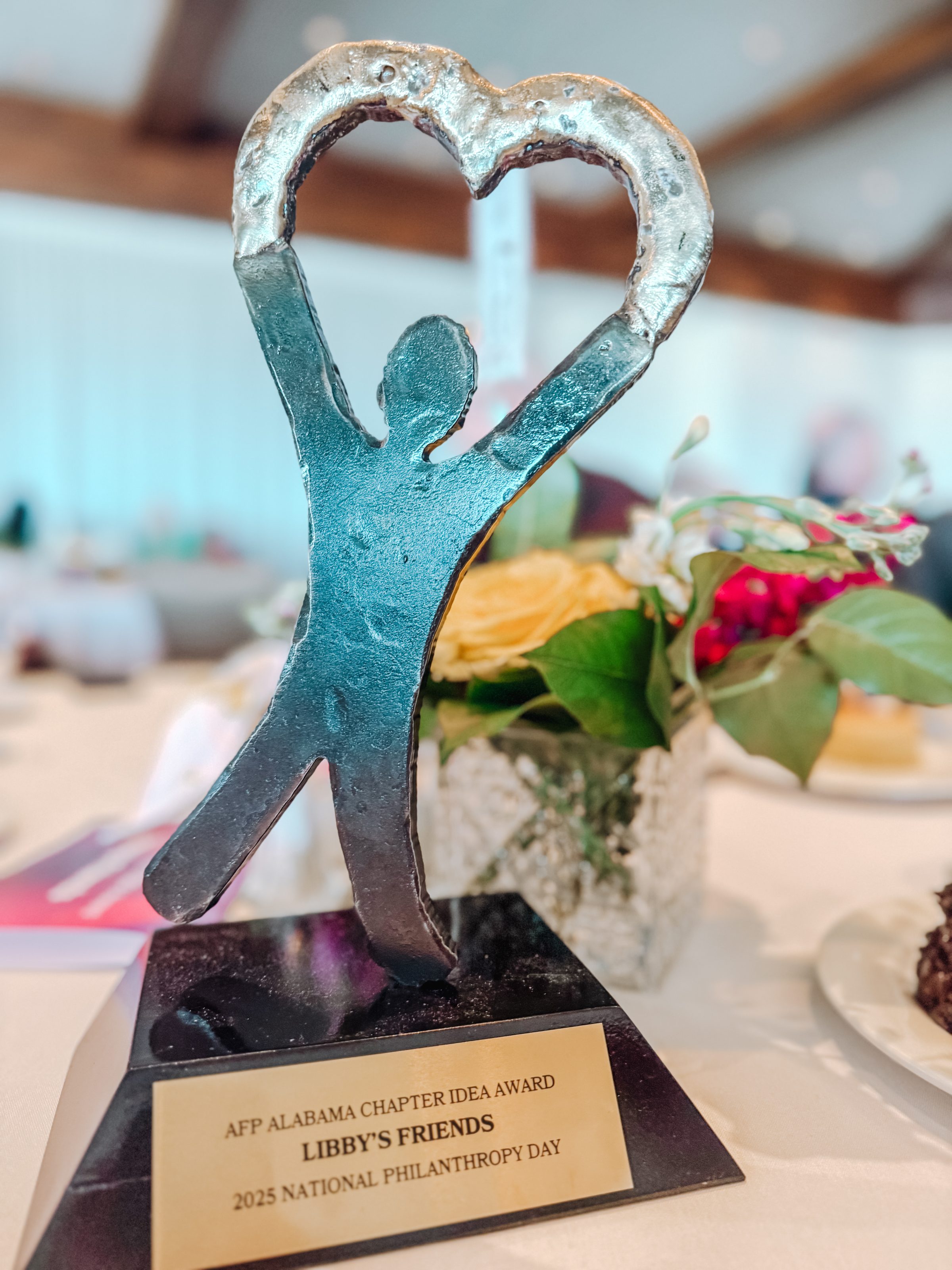 Figure holding heart award trophy, AFP Alabama Chapter Idea Award for Libby's Friends, 2025 National Philanthropy Day